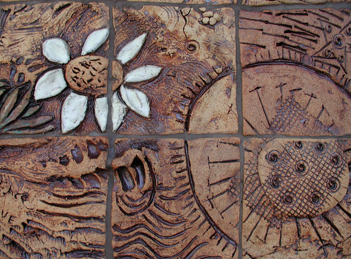 Detail of handmade ceramic tile mural with flower motif. 